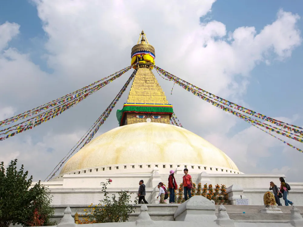 Boudhanath stupa with prayer flags under a bright sky