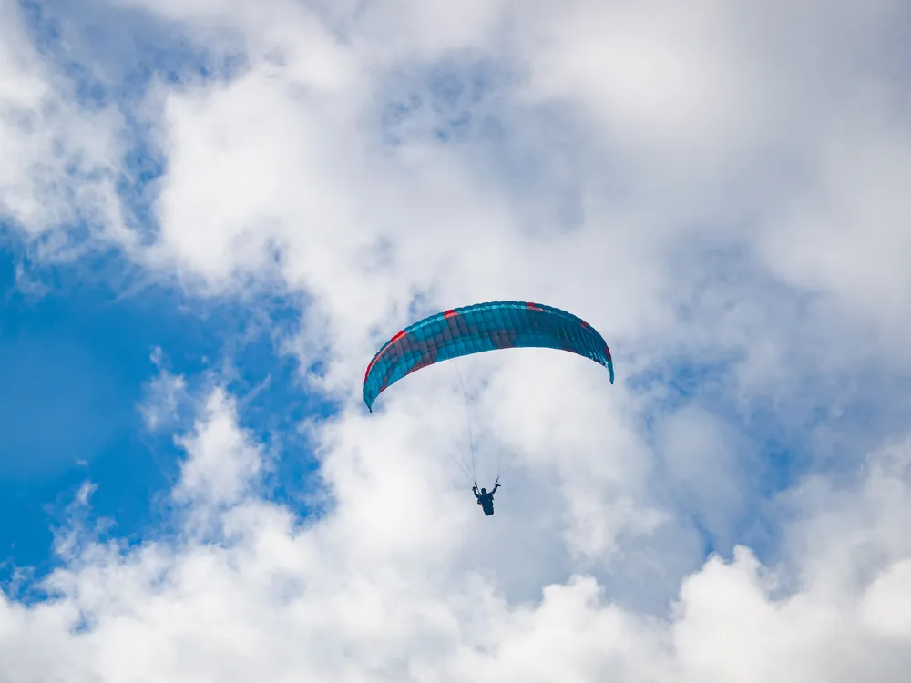 A paraglider in a cloudy sky over Nepal