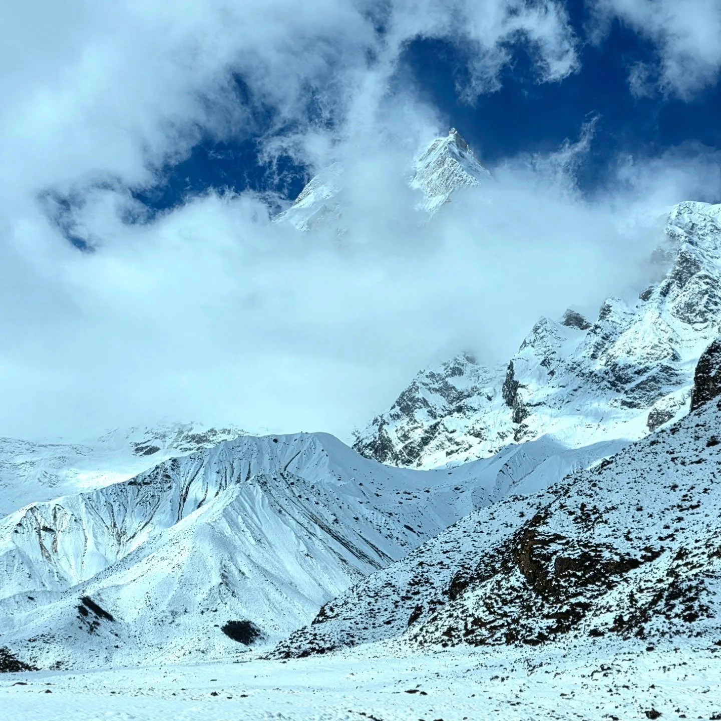 Snow-covered high valley and cloud-wrapped peaks above 4,000m on the Manaslu Circuit in Nepal