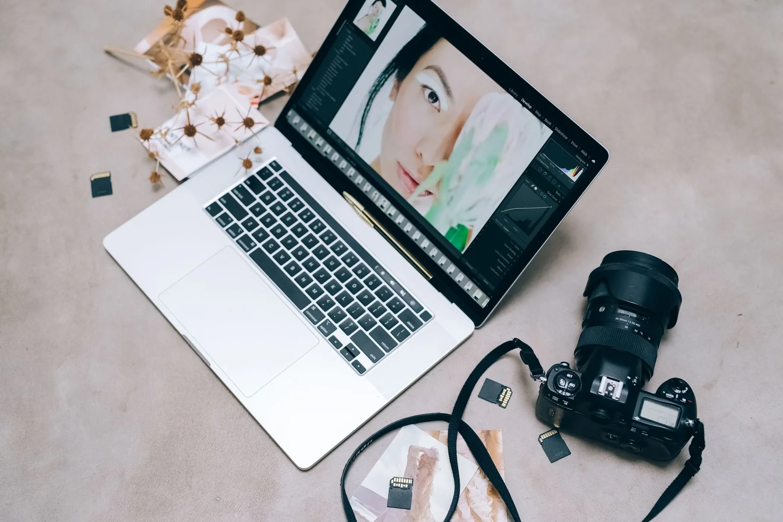 A camera memory card, a laptop and a small external drive on a desk — copying and backing up travel photos