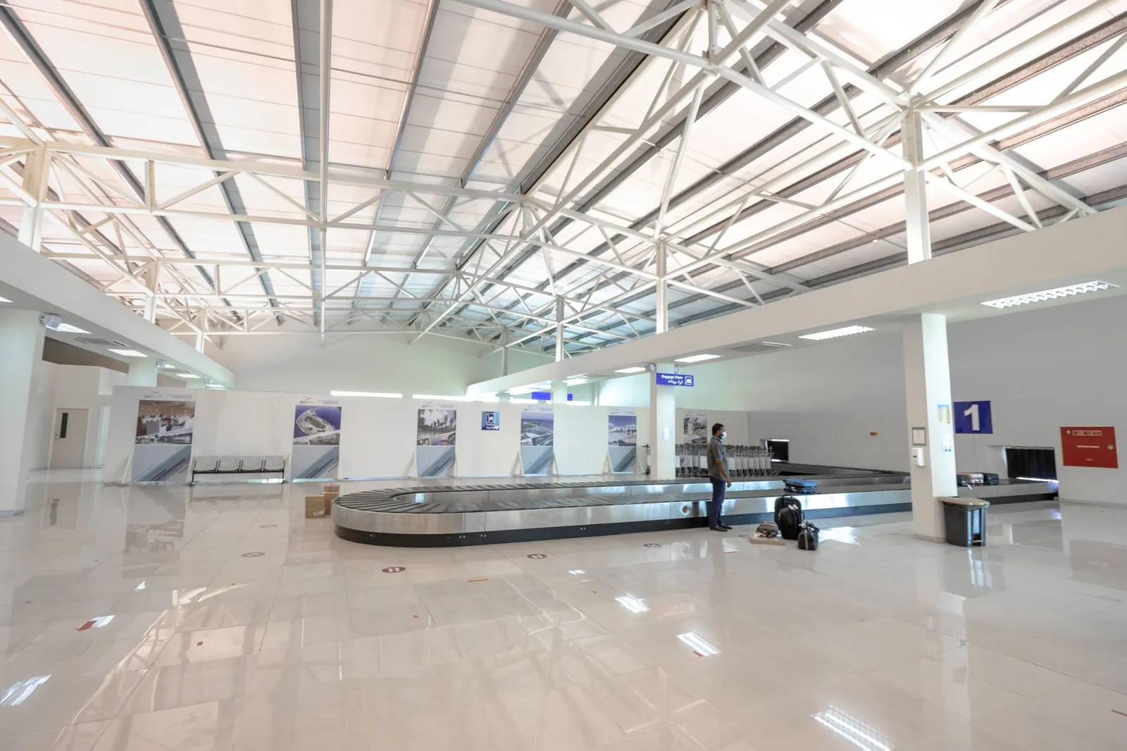 Suitcases circling a baggage-reclaim carousel in an airport arrivals hall — where delayed and lost luggage claims begin