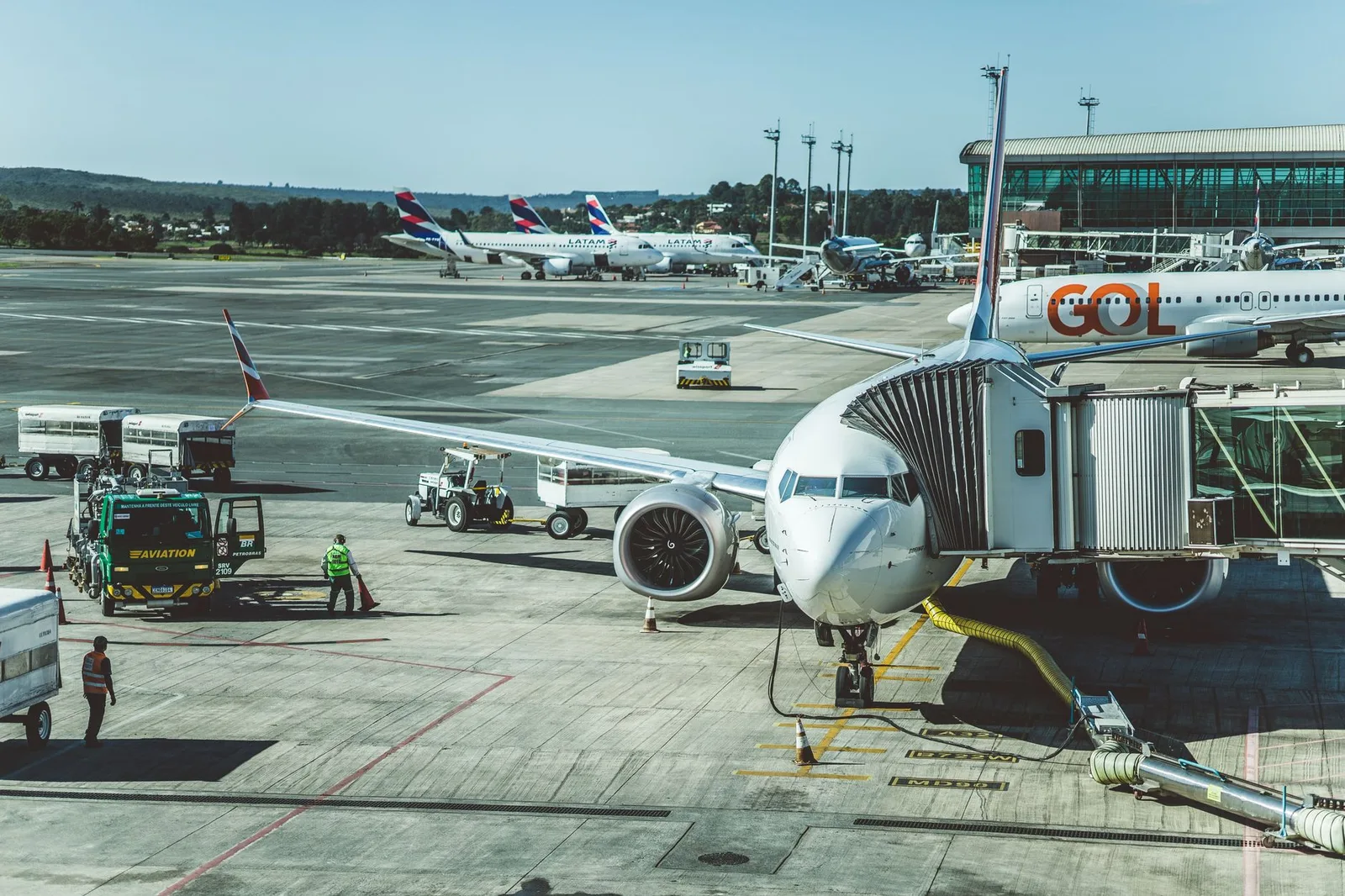 Passengers boarding a passenger jet at an airport gate via the jet bridge