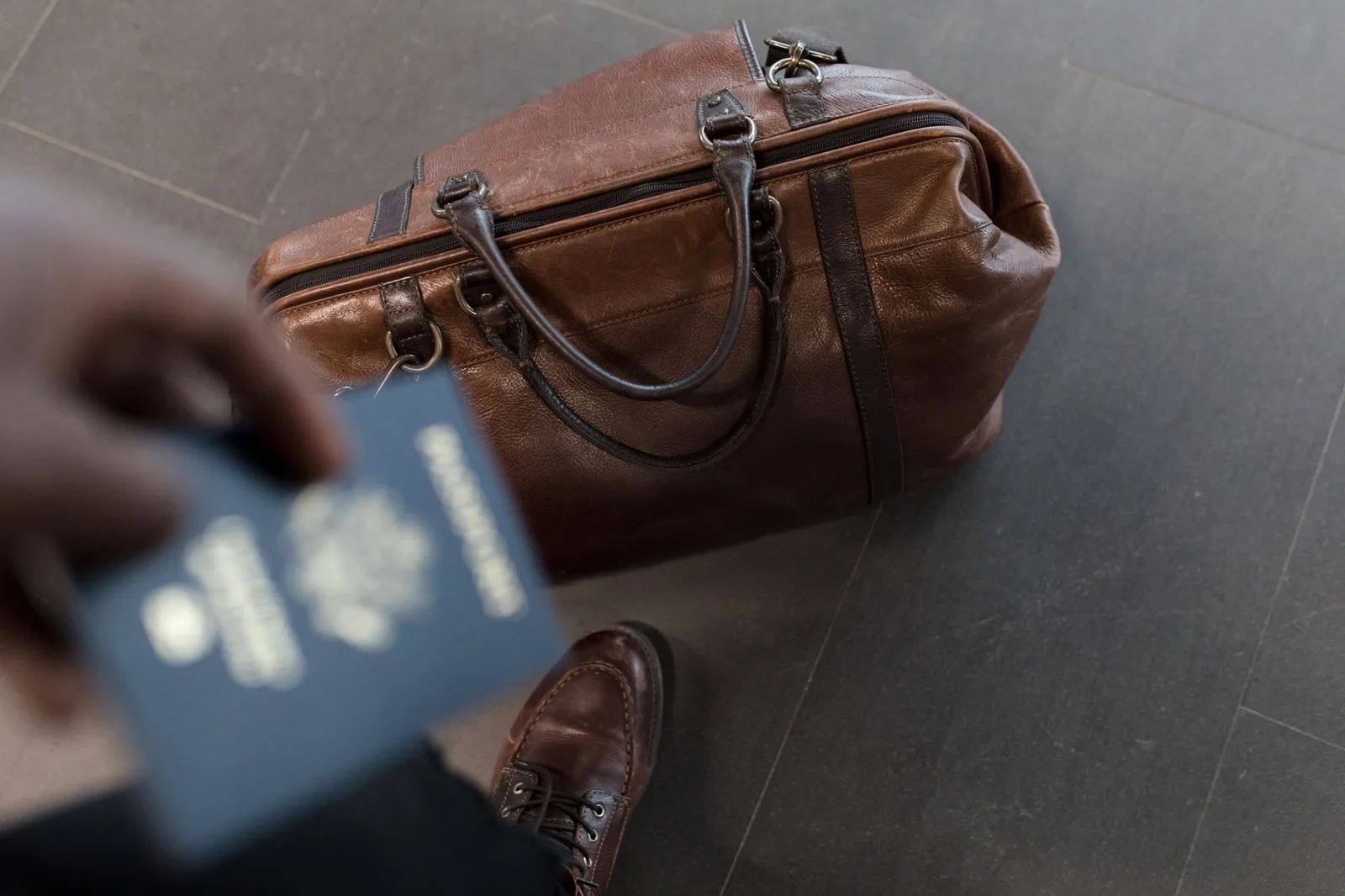 A Canadian passport at an airport departures area — visa-exempt travellers flying to Canada need an approved eTA linked to their passport