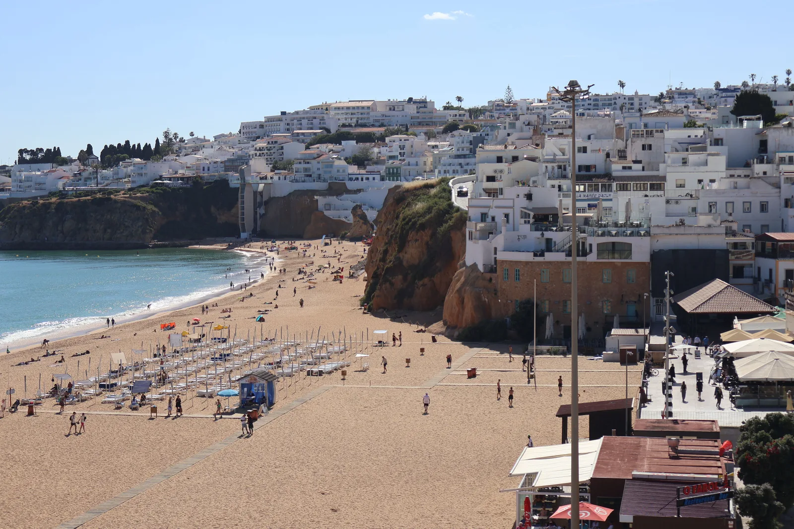 Whitewashed cliffs above a turquoise cove on Portugal's Algarve coast — one of Europe's most affordable retirement destinations, 2026