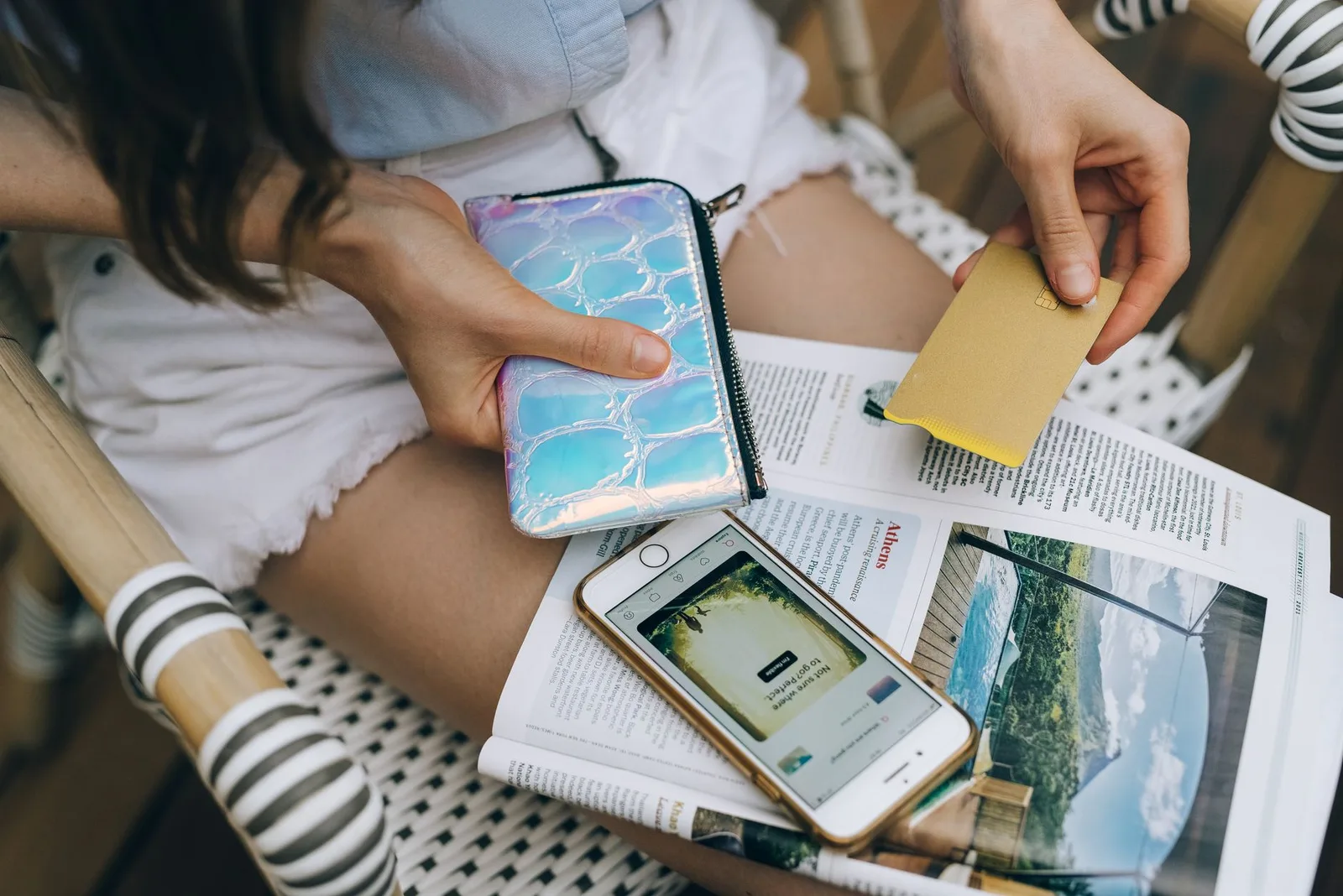 A hand holding several credit cards from an open wallet, the way many travellers assume their card covers their trip