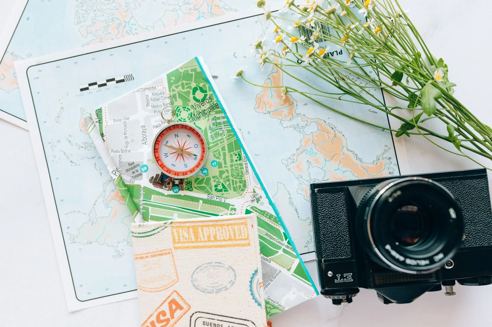 A passport open to pages of visa stamps and stickers beside a laptop showing an online visa application — the documents behind ETAs, eVisas and traditional visas