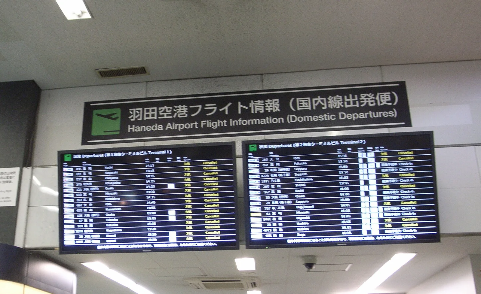 An airport information board displaying multiple cancelled and delayed flights, illustrating passenger compensation rights in 2026