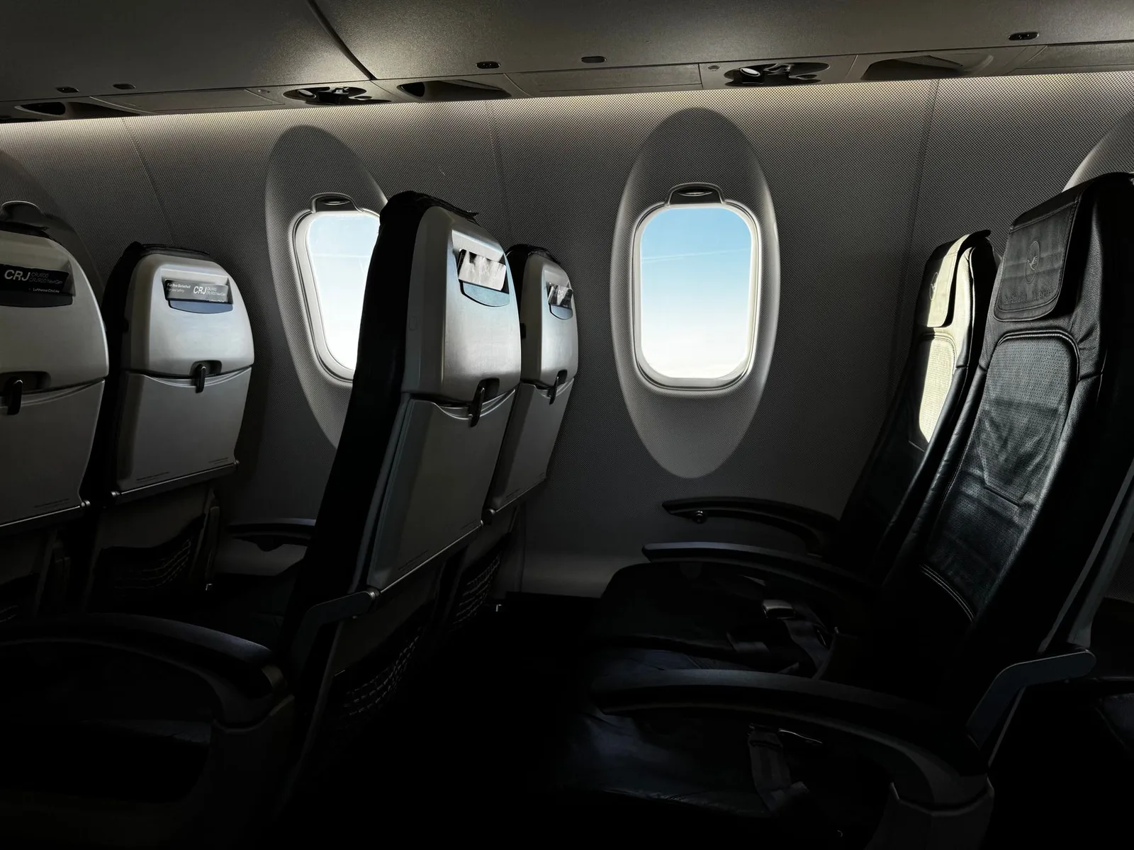 Empty seats and windows inside an airliner cabin with daylight streaming in, evoking the long-haul flights that cause jet lag
