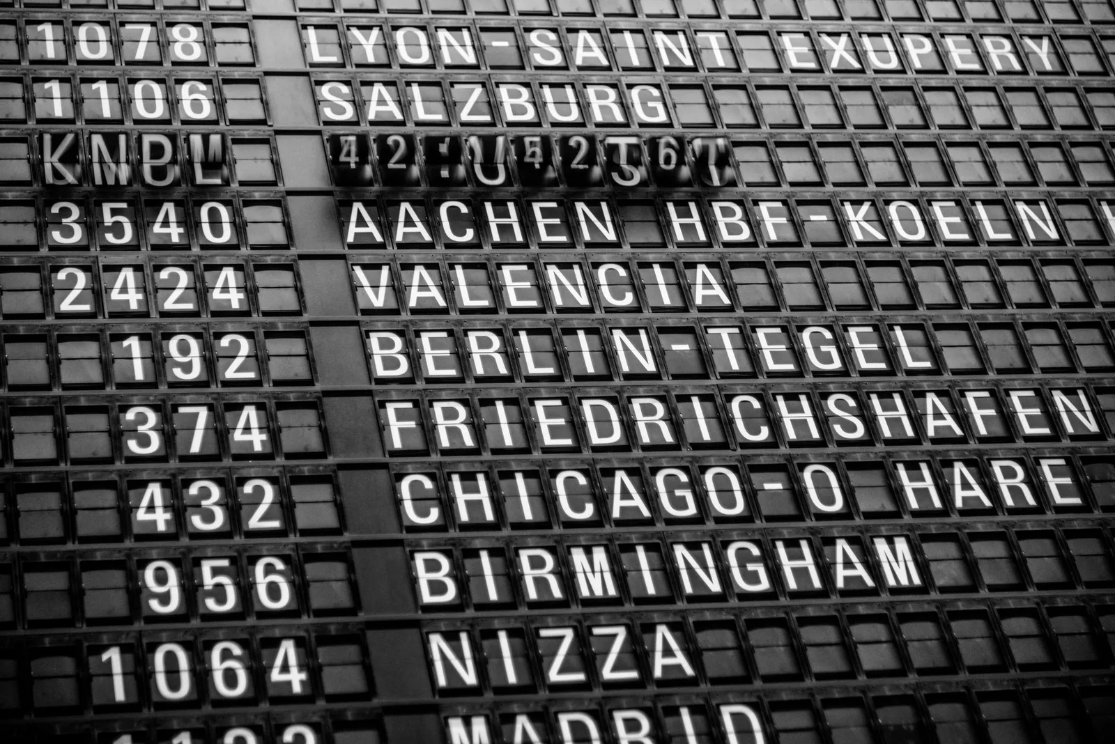 A departures board at an airport terminal listing flight times and gates