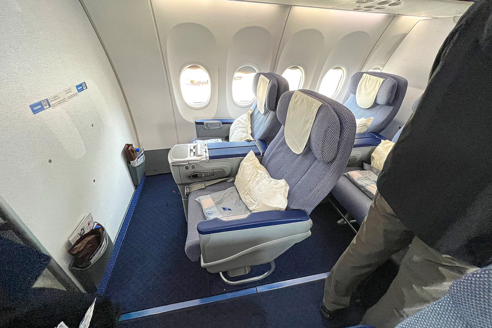 A wide-body airline business-class cabin with staggered lie-flat seats — how to book premium cabins for less in 2026