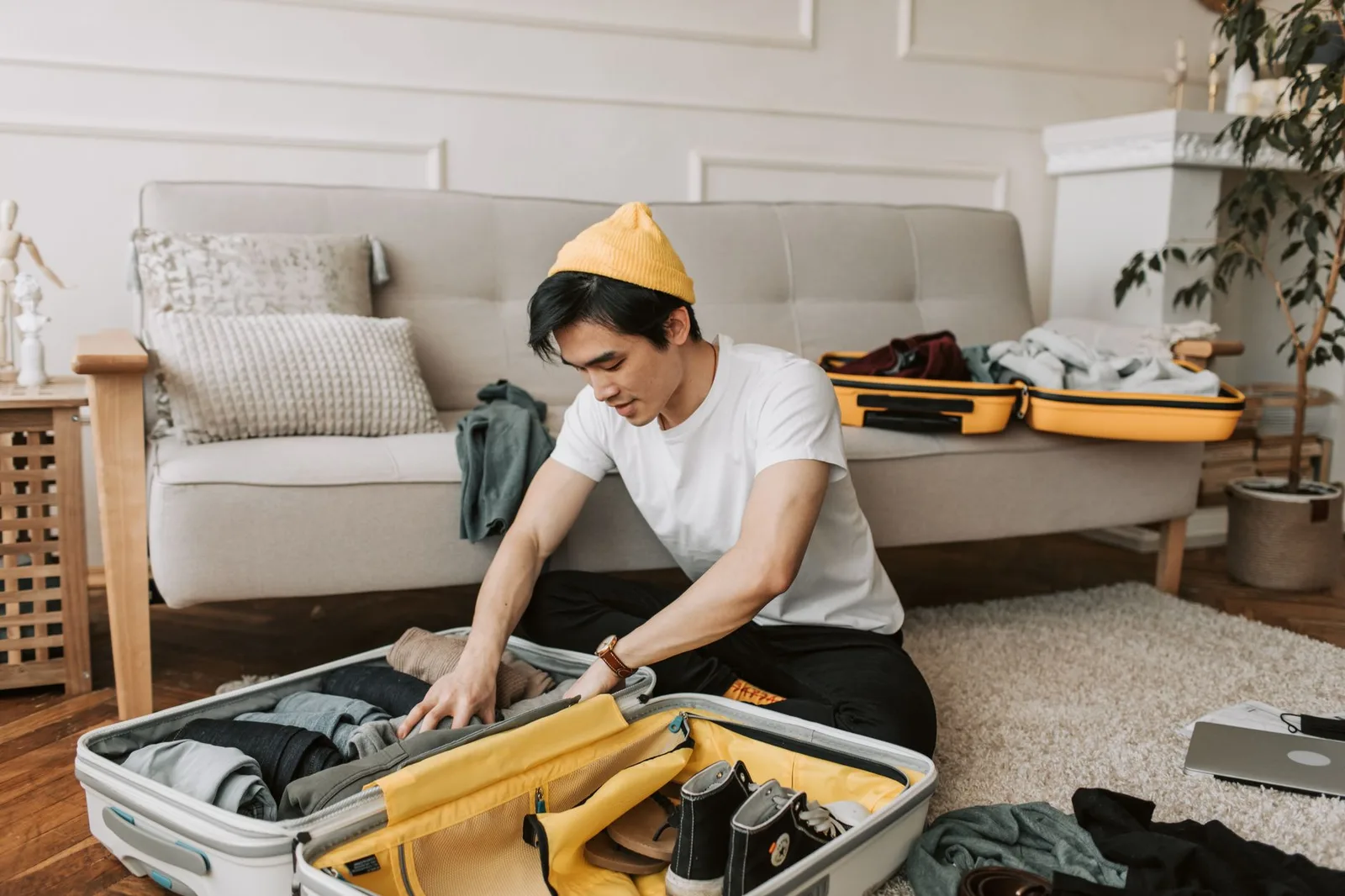 Clothes and travel items laid out and packed into a carry-on bag for a trip