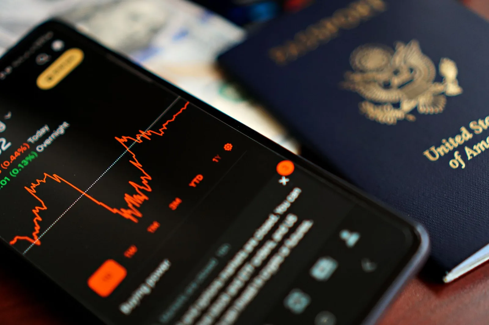 A United States passport rests on a desk beside a smartphone — plan your passport renewal well ahead of 2026 travel.