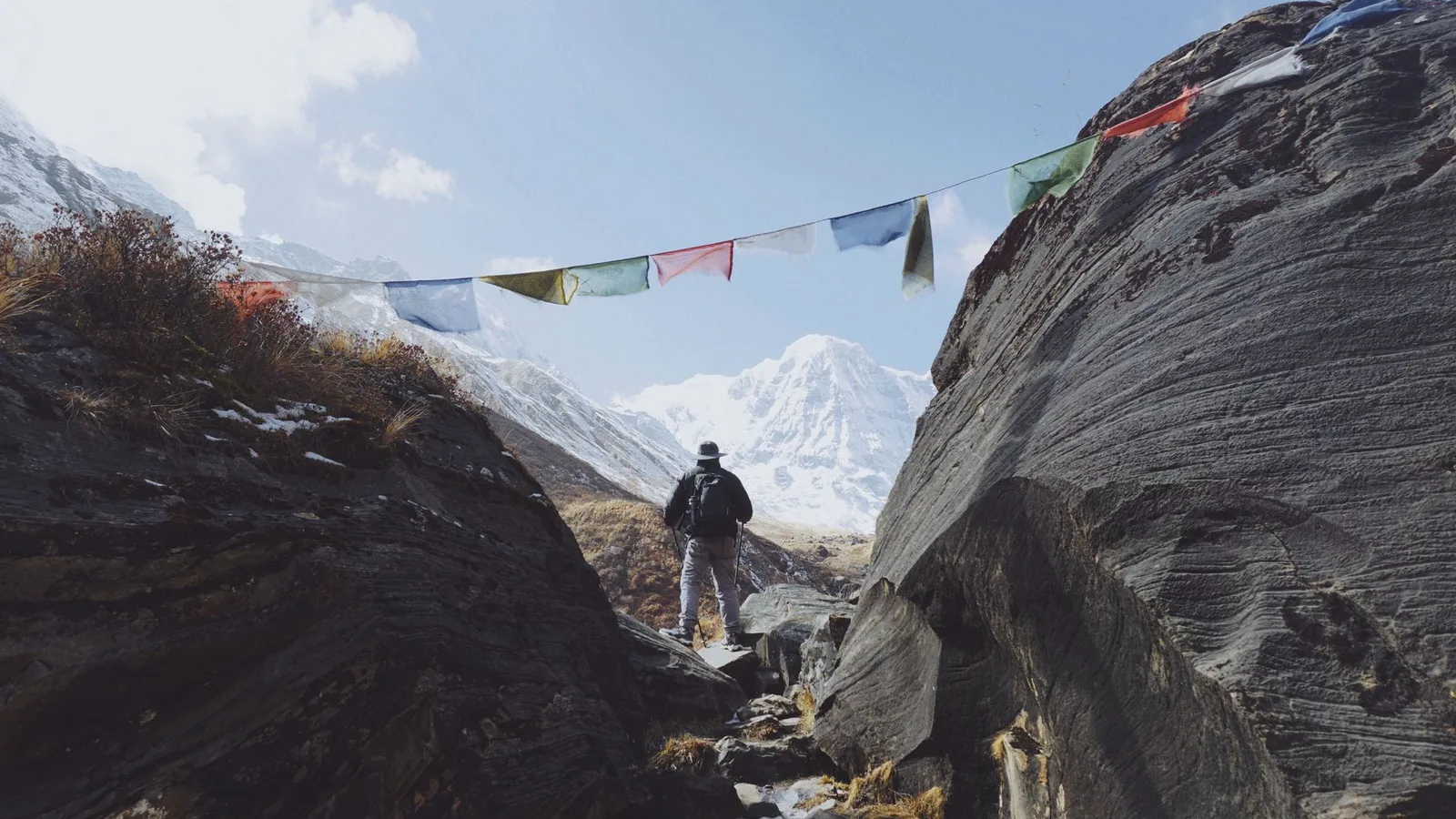 File photo: a trekking trail with Buddhist prayer flags in the Nepal Himalaya (illustrative; not the flood-affected area)