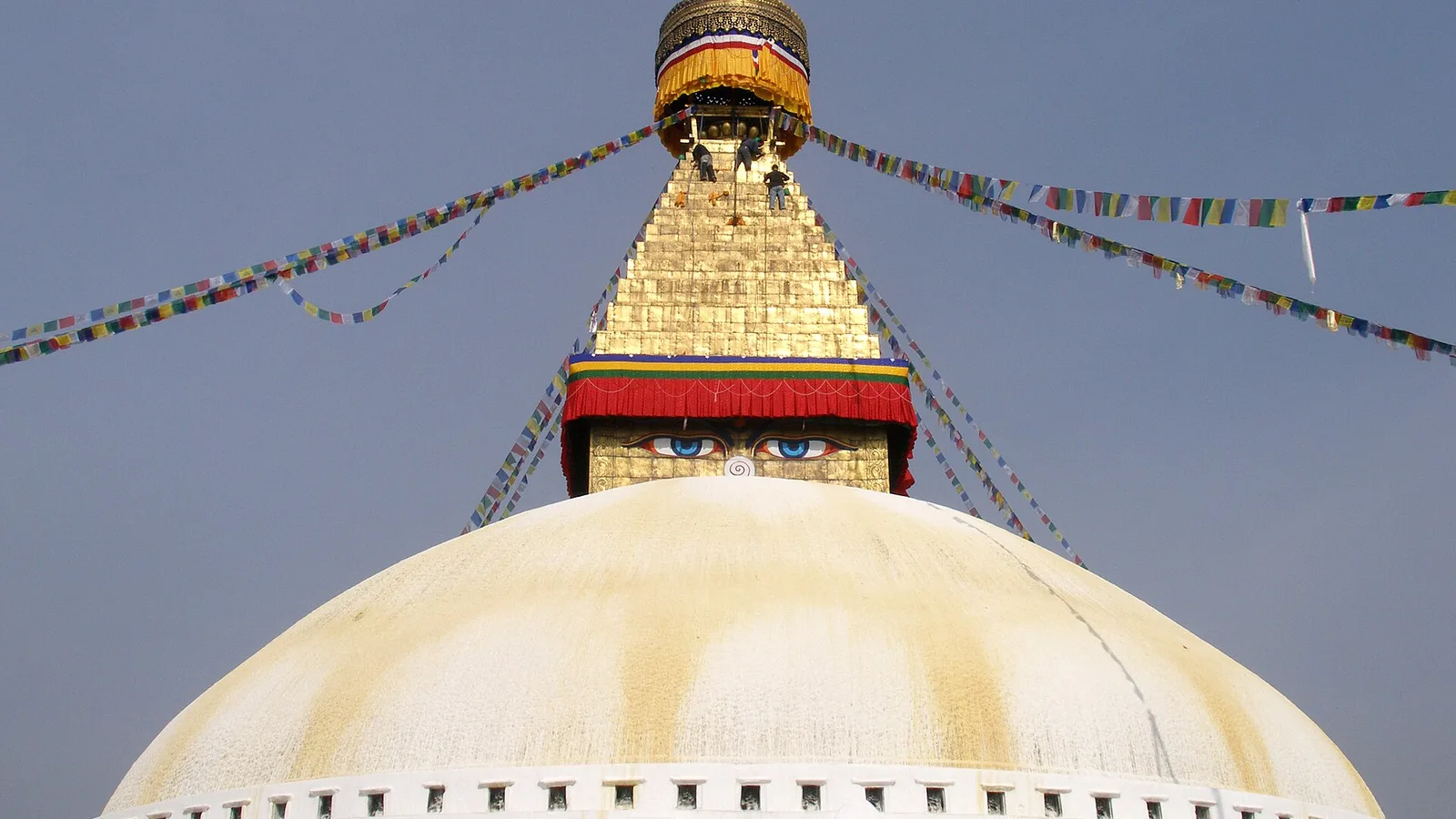 The great white dome and gilded spire of Boudhanath Stupa, its painted Buddha eyes gazing out over the rooftops of Kathmandu, Nepal