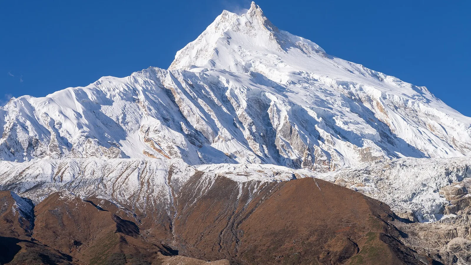 Mount Manaslu (8,163 m), the world's eighth-highest peak, rising above the Budhi Gandaki valley on the Manaslu Circuit in the Gorkha region of Nepal — a restricted-area trek whose two-person permit minimum was scrapped in March 2026