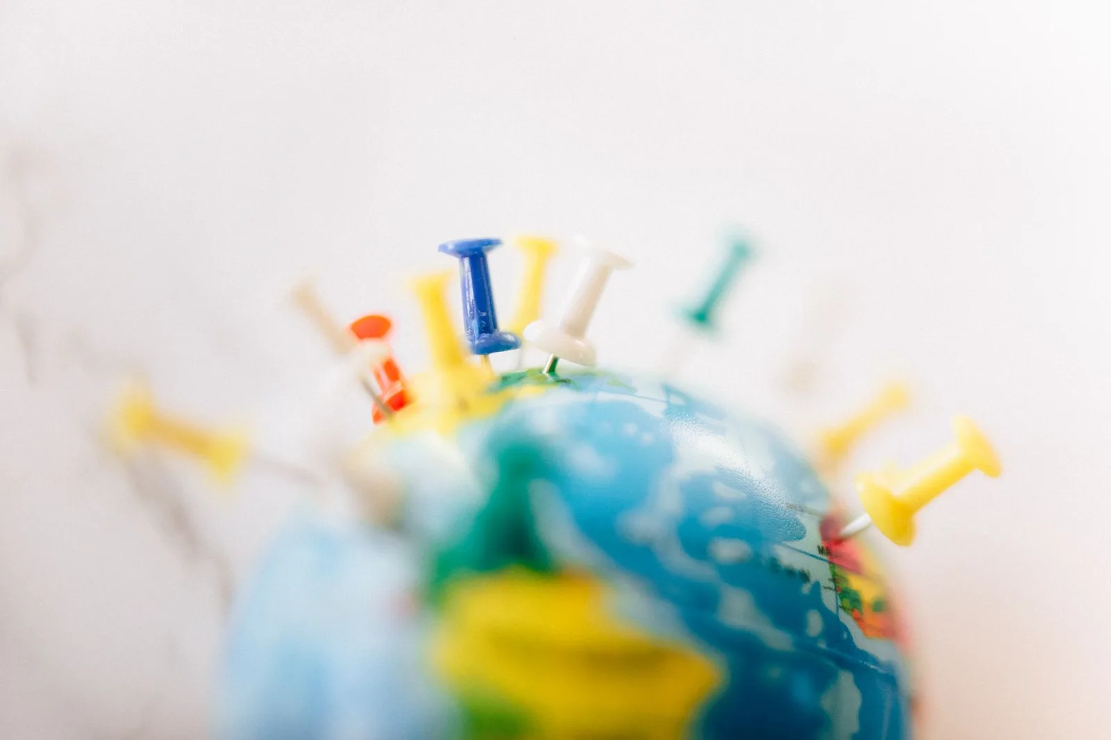 A world map marked with pins and route lines for a multi-stop trip beside a passport and boarding pass — planning an open-jaw or multi-city flight itinerary