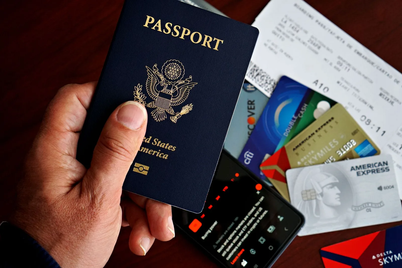 An open passport showing its stamped and blank inside pages beside a boarding pass — the passport-validity, blank-page and name-match details that decide whether a traveller is allowed to board and enter