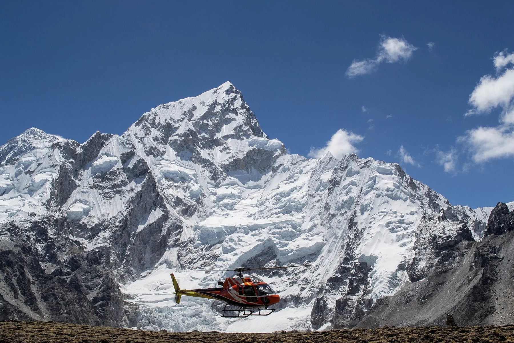 A helicopter departs Everest Base Camp in Nepal's Khumbu region, high beneath the Himalaya — the type of aircraft used for high-altitude long-line rescues.