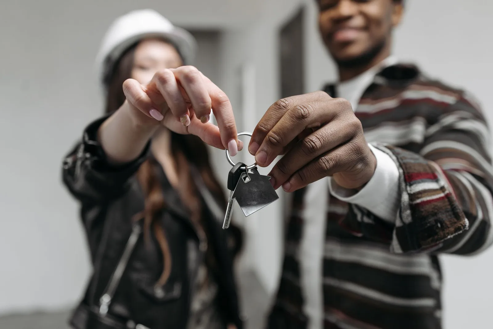 A set of car keys being handed over a rental car hire desk