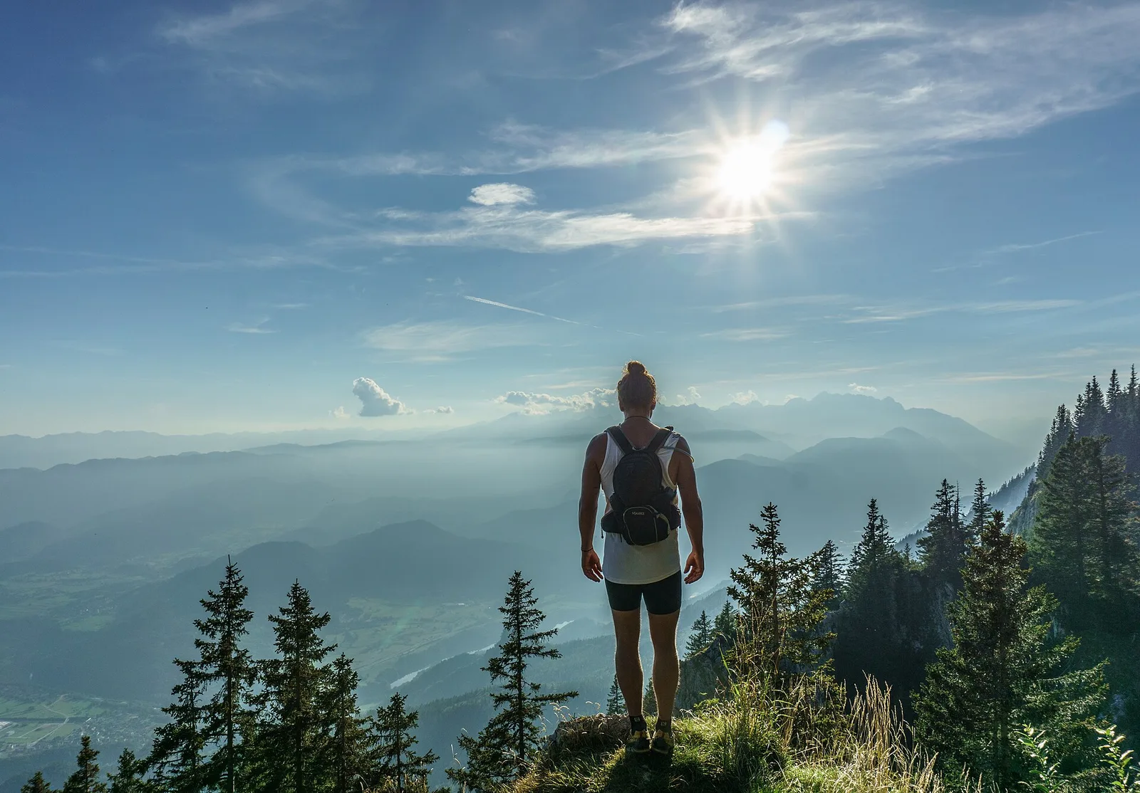 A solo woman hiker looks out from a mountaintop — the safest countries for solo female travellers in 2026