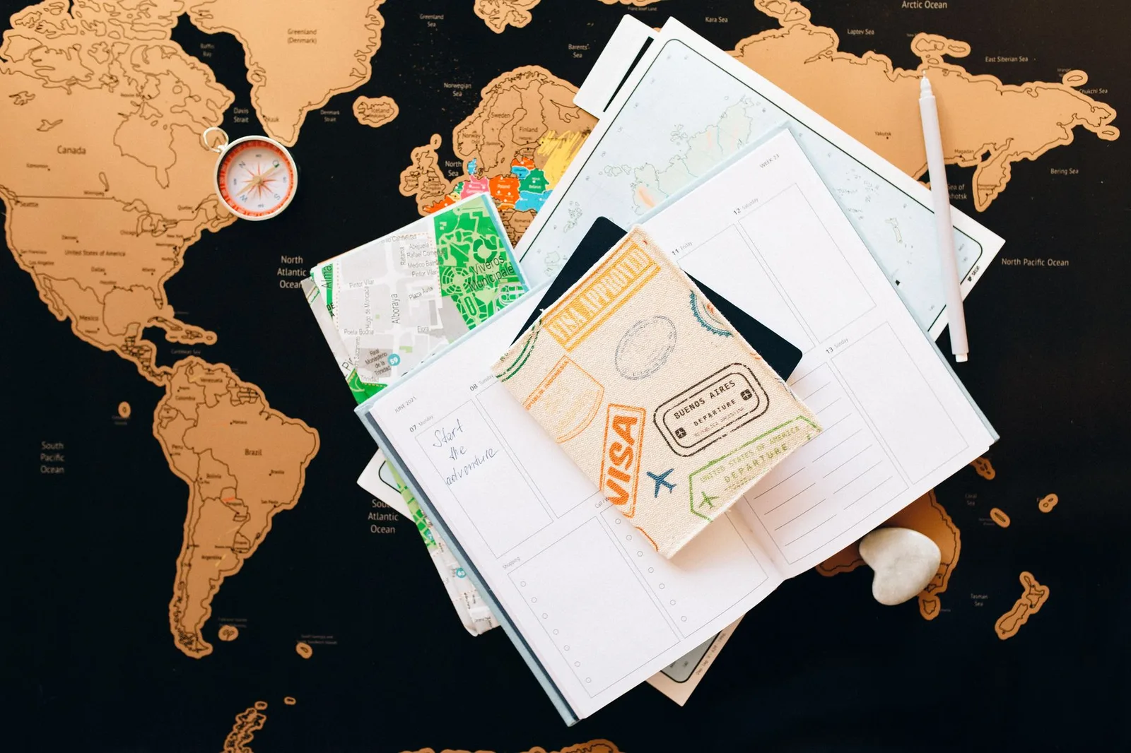 An open passport showing visa stickers and stamped entry pages beside travel documents — applying for a short-stay Schengen visa