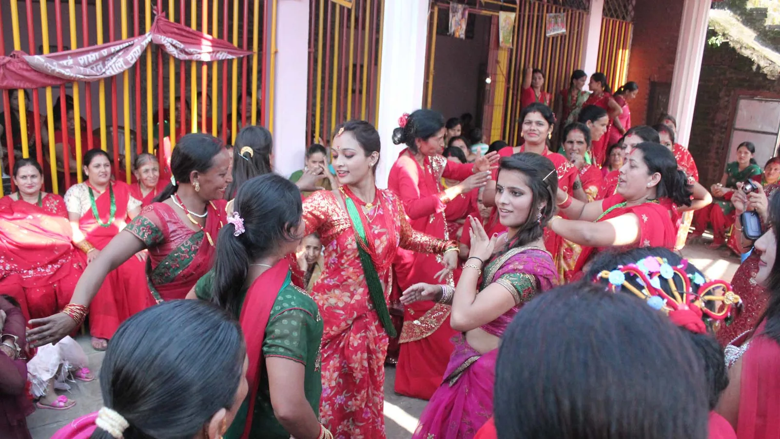 Women in red saris celebrating the Teej festival in Nepal, gathering to sing, dance and worship Shiva