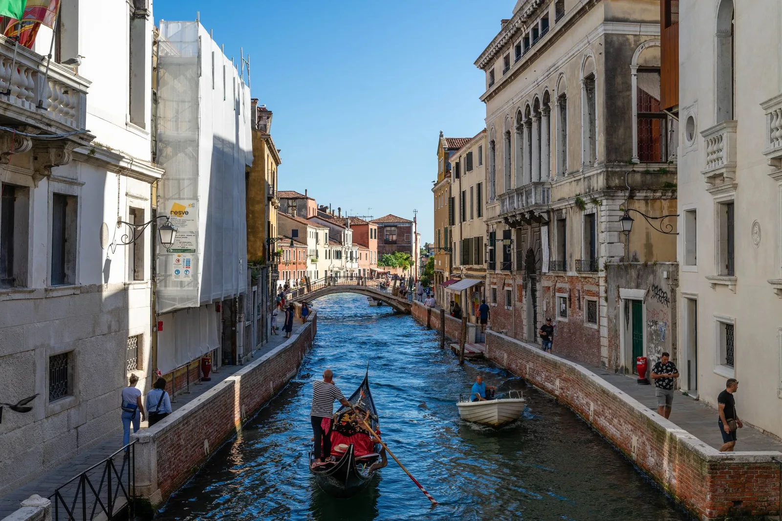 Gondolas and tourists on a canal in Venice, Italy, one of the destinations charging a visitor access fee