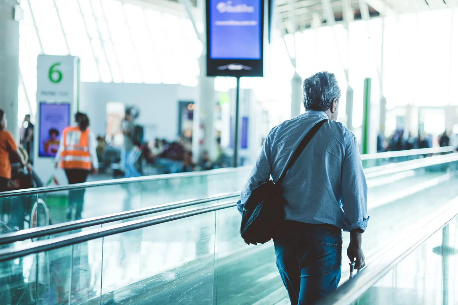 Travelers walking through an international airport terminal between connecting flights