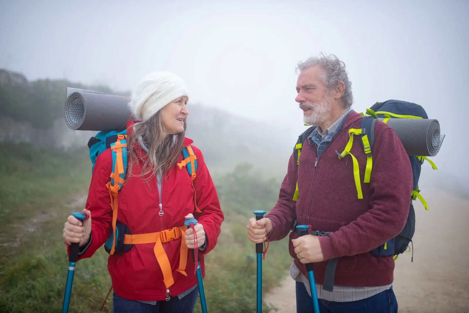 An older couple hiking together on a mountain trail
