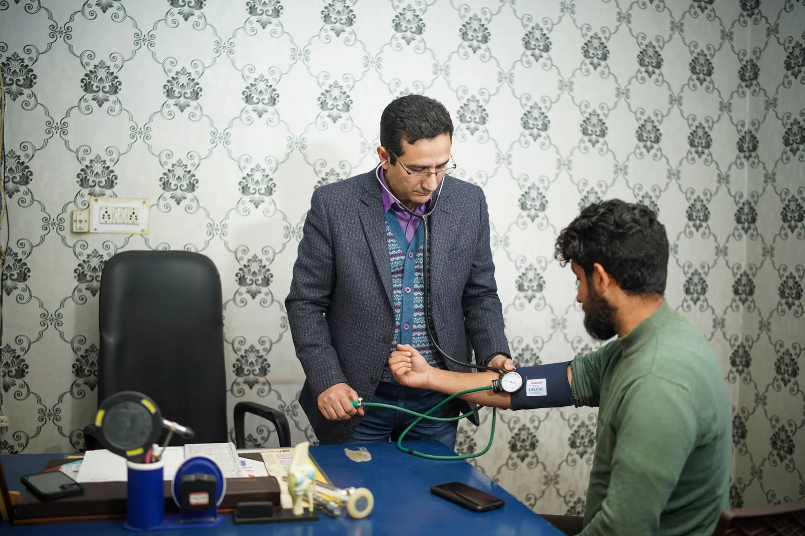 A doctor checking an older patient’s blood pressure during a medical check-up — illustrative of the health screening behind declaring a pre-existing condition for travel insurance