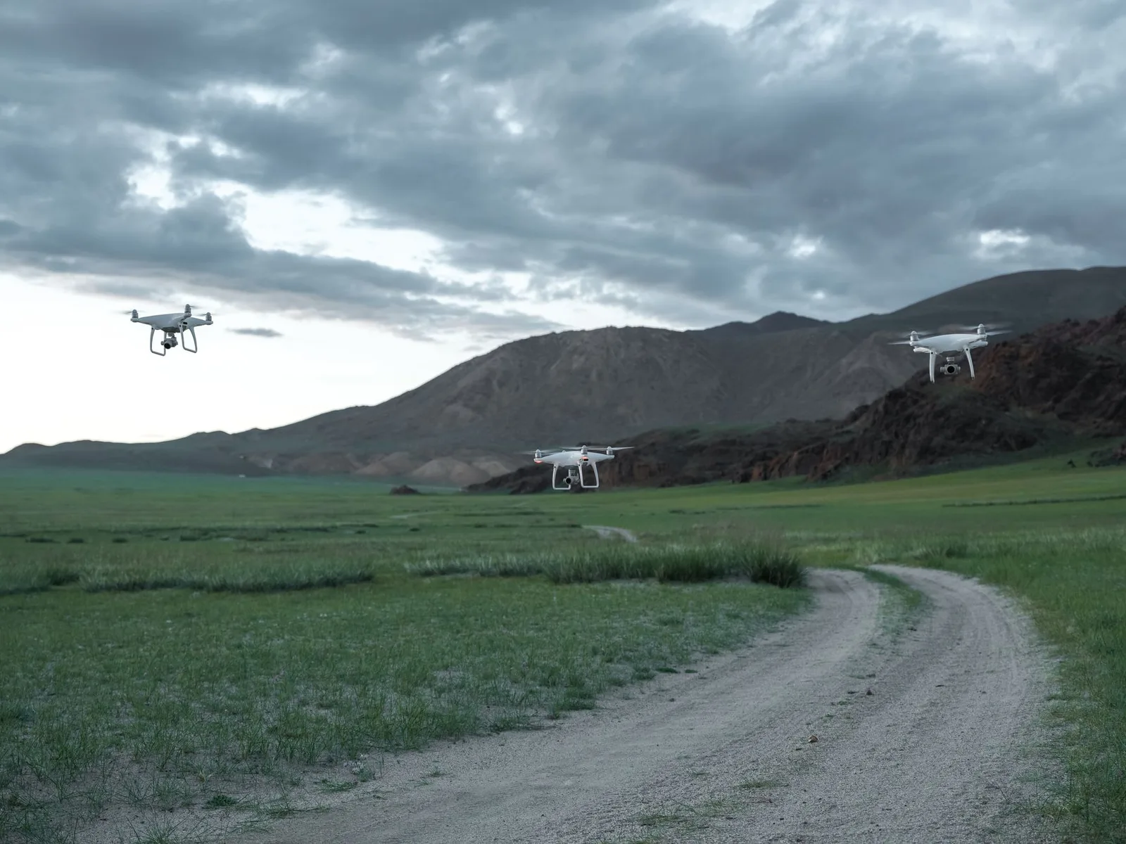 A camera drone hovering in the air over an open mountain landscape — travelling abroad with a drone means checking each country’s rules first