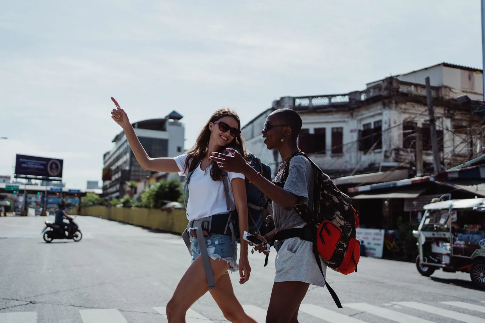 A young backpacker with a large travel rucksack walking through a city — working holiday visas let under-30s live and work abroad for a year or two