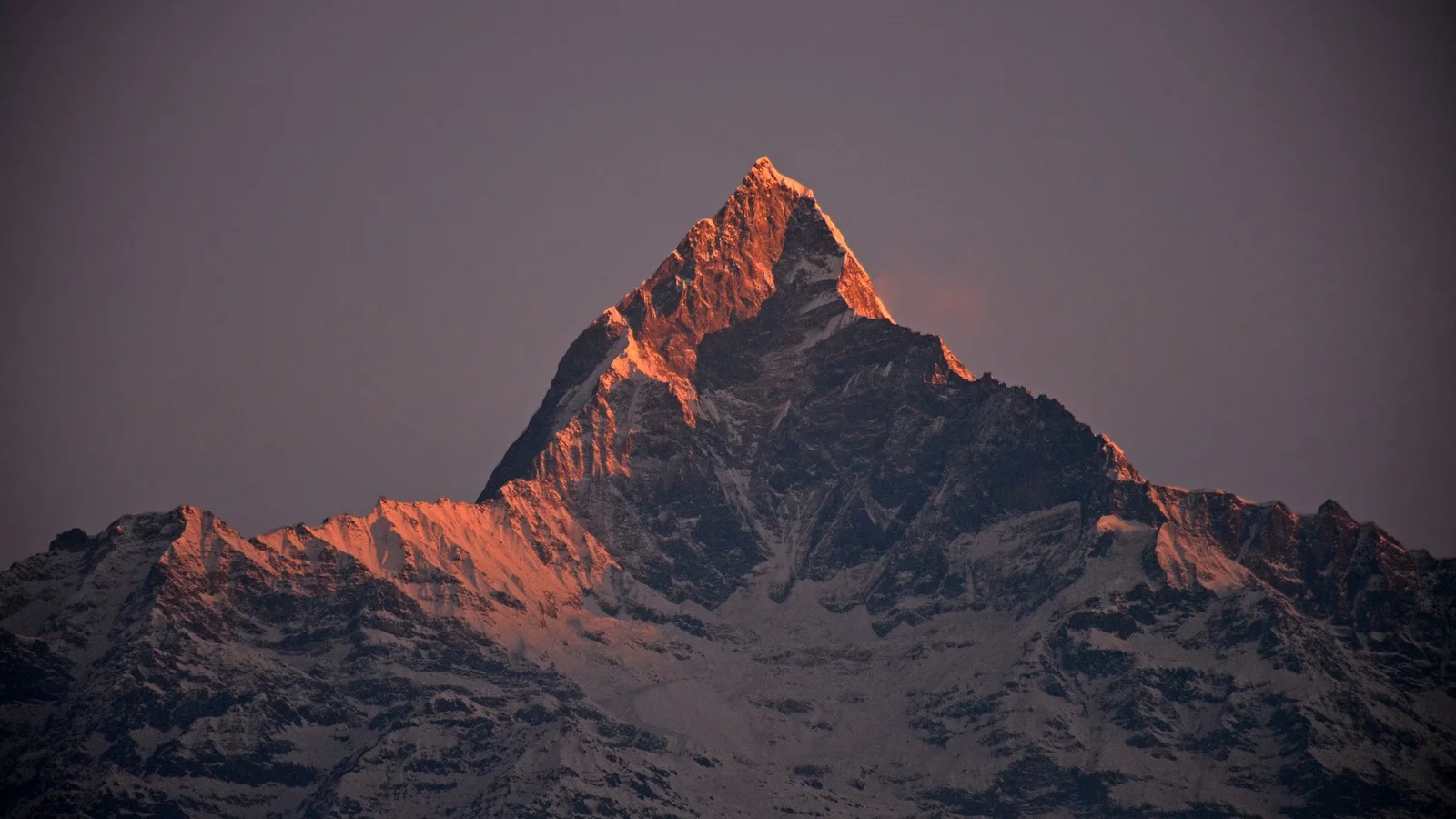 A stunning sunset captures the snow-covered Machapuchare Peak in the Annapurna range, Nepal.