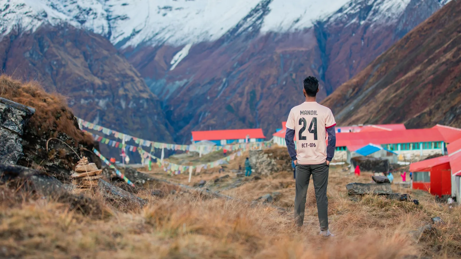 A man stands in Koshi Province, Nepal, overlooking the snowcapped Annapurna mountains.
