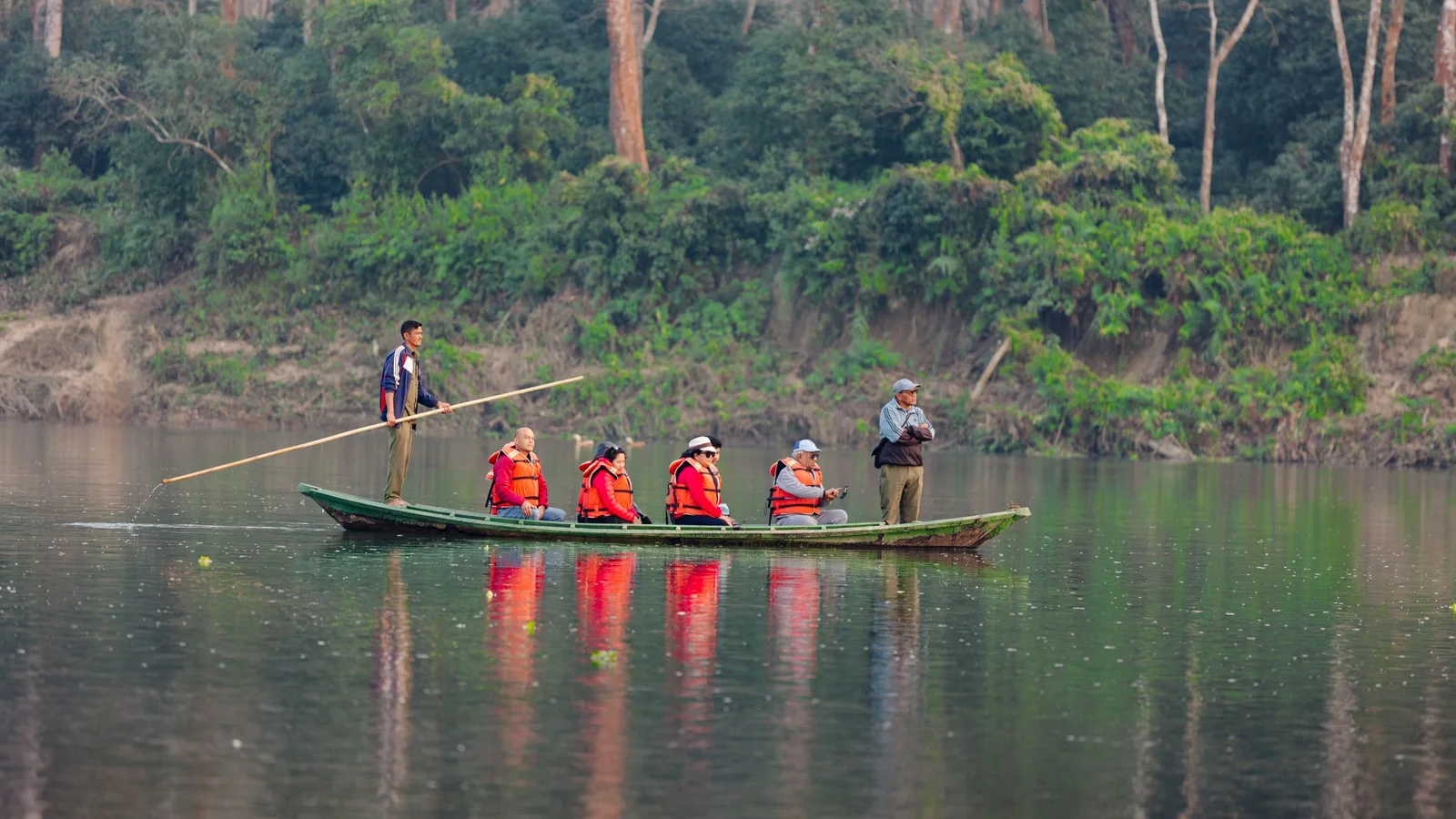 Group enjoying guided canoe ride on a calm forest lake with life jackets
