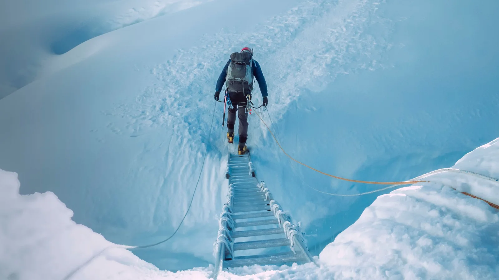 Brave climbers cross a snowy ridge in Khumjung, Nepal, showcasing extreme mountain adventure.