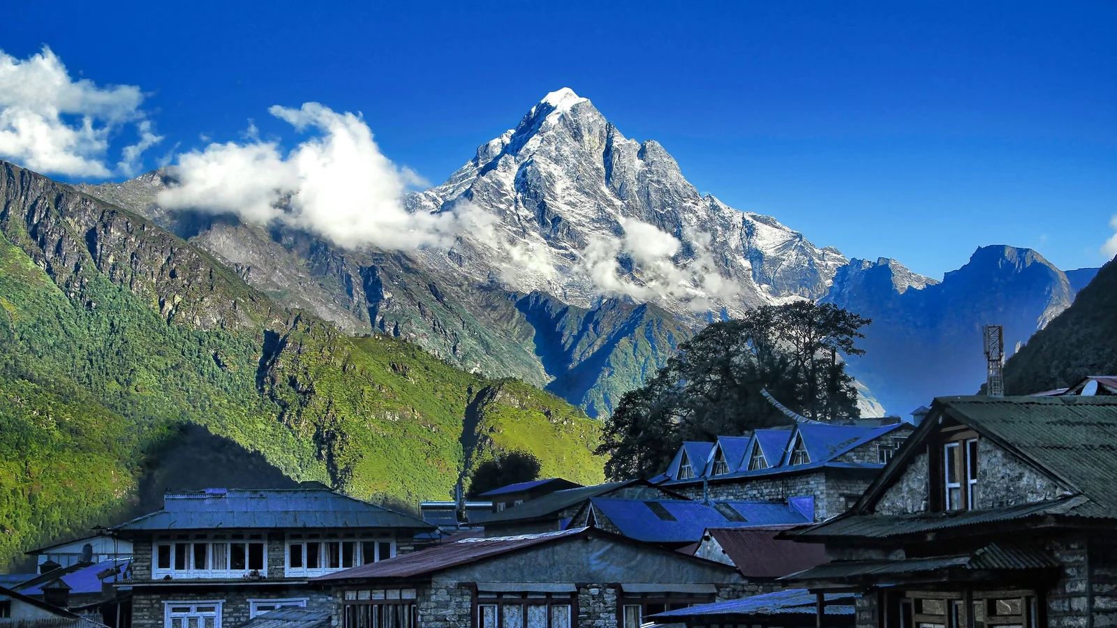 Breathtaking view of the Himalayas with traditional Nepalese houses in the foreground.