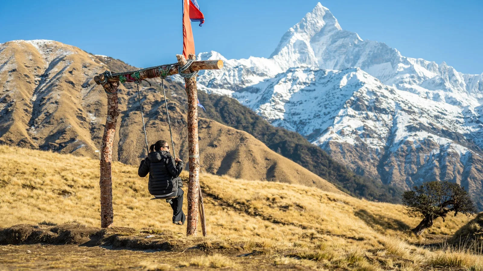 A woman enjoys a swing with a stunning view of the Annapurna mountain range in Pokhara, Nepal.