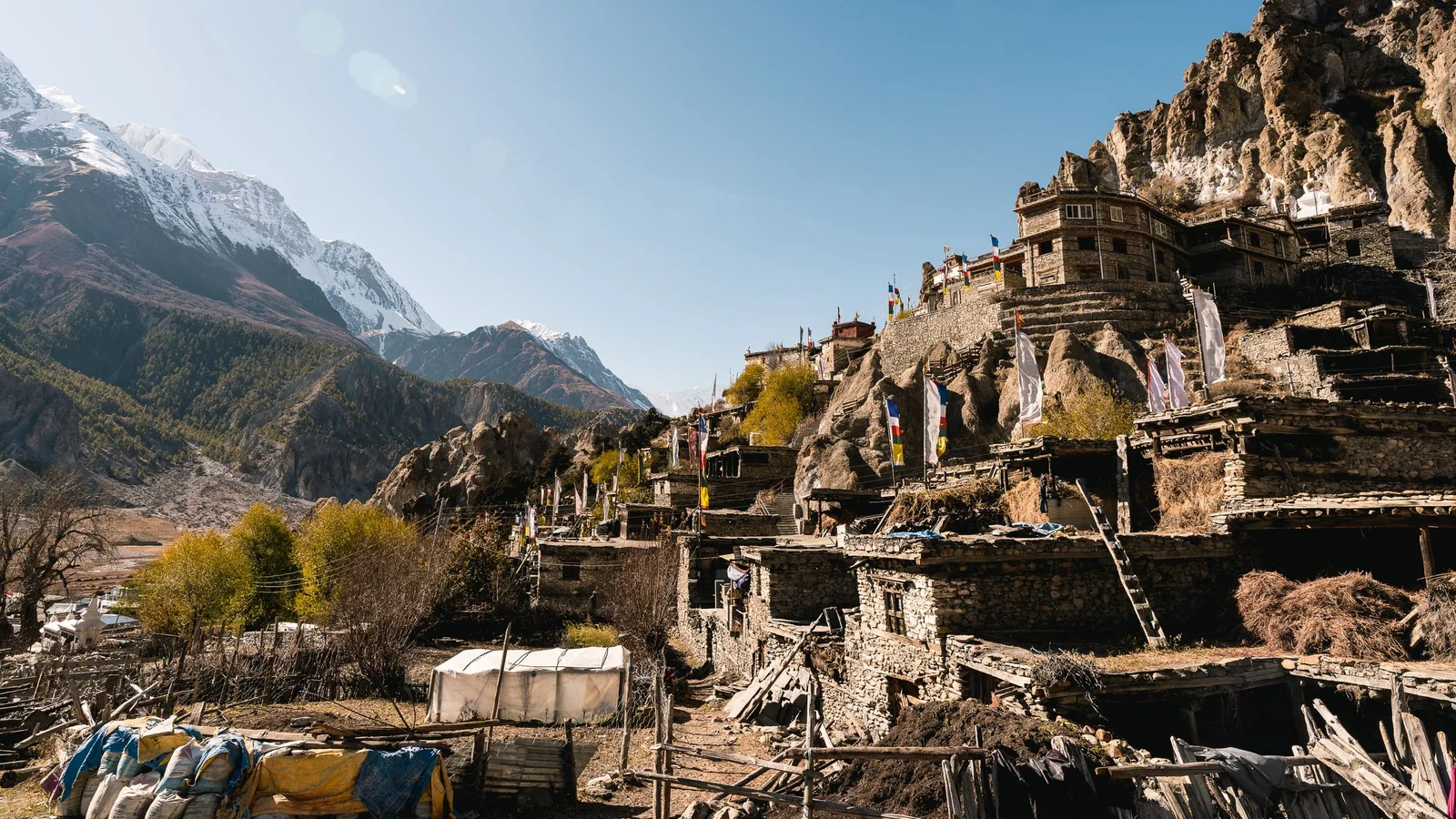 A scenic view of a traditional Nepalese village set against the majestic Himalayas.